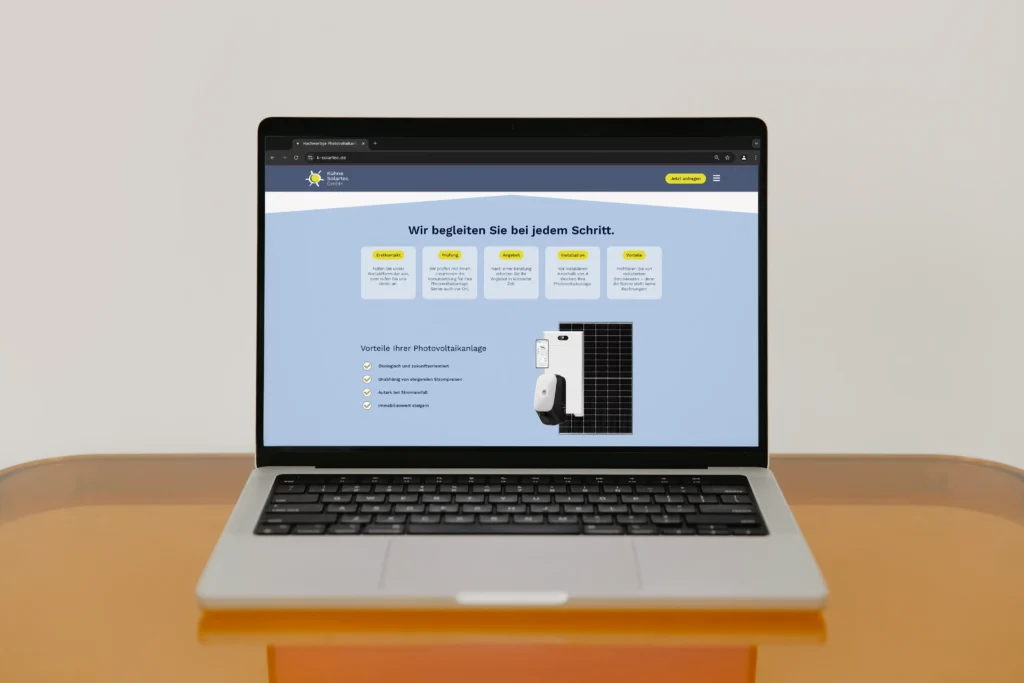 Laptop mit geöffneter Website der Colbec GmbH – Projektansicht für Solartec auf orangefarbenem Tisch